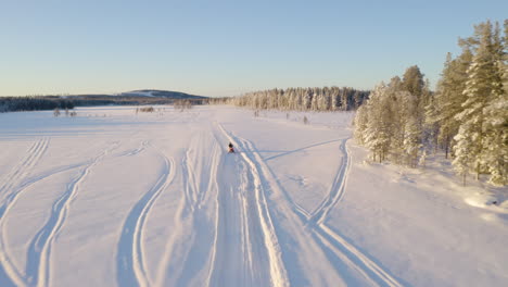 aerial view above three snowmobiles riding across snowy lapland sweden wilderness trail