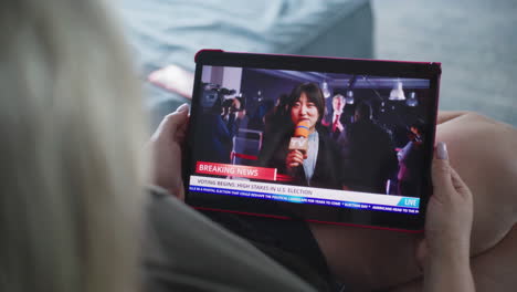 woman watching news coverage of us election on tablet