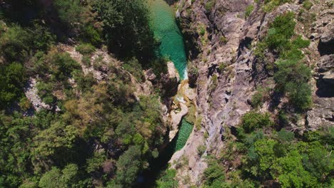 Aerial-view-over-waterfalls-and-mountain-ravines-with-Mediterranean-forest-and-river-bed