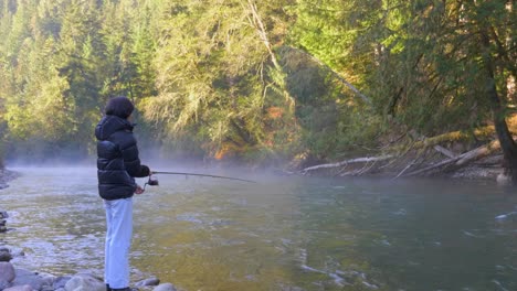 Frau-Steht-An-Einem-Kalten-Tag-Am-Fluss-Und-Fischt