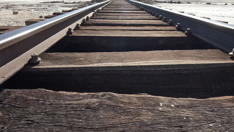 low dolly along metal tracks with wooden support beams in desert of bolivia