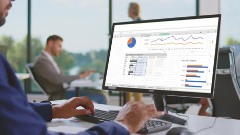 business person analyzing financial data on computer in office