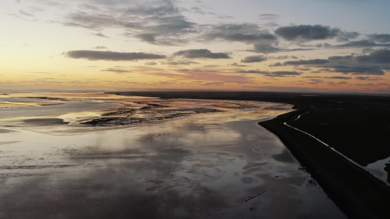 reflejos aéreos de la puesta de sol de color naranja dorado sobre las aguas en ameland