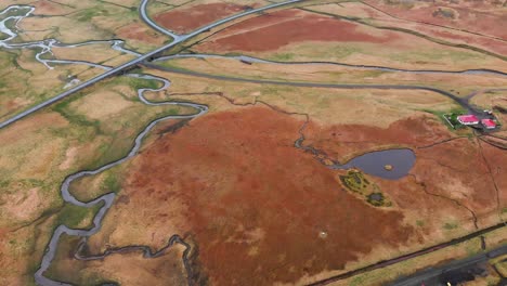 Aerial-footage-looking-down-at-a-river-coming-from-Bjarnarfoss-waterfall,-Iceland-1