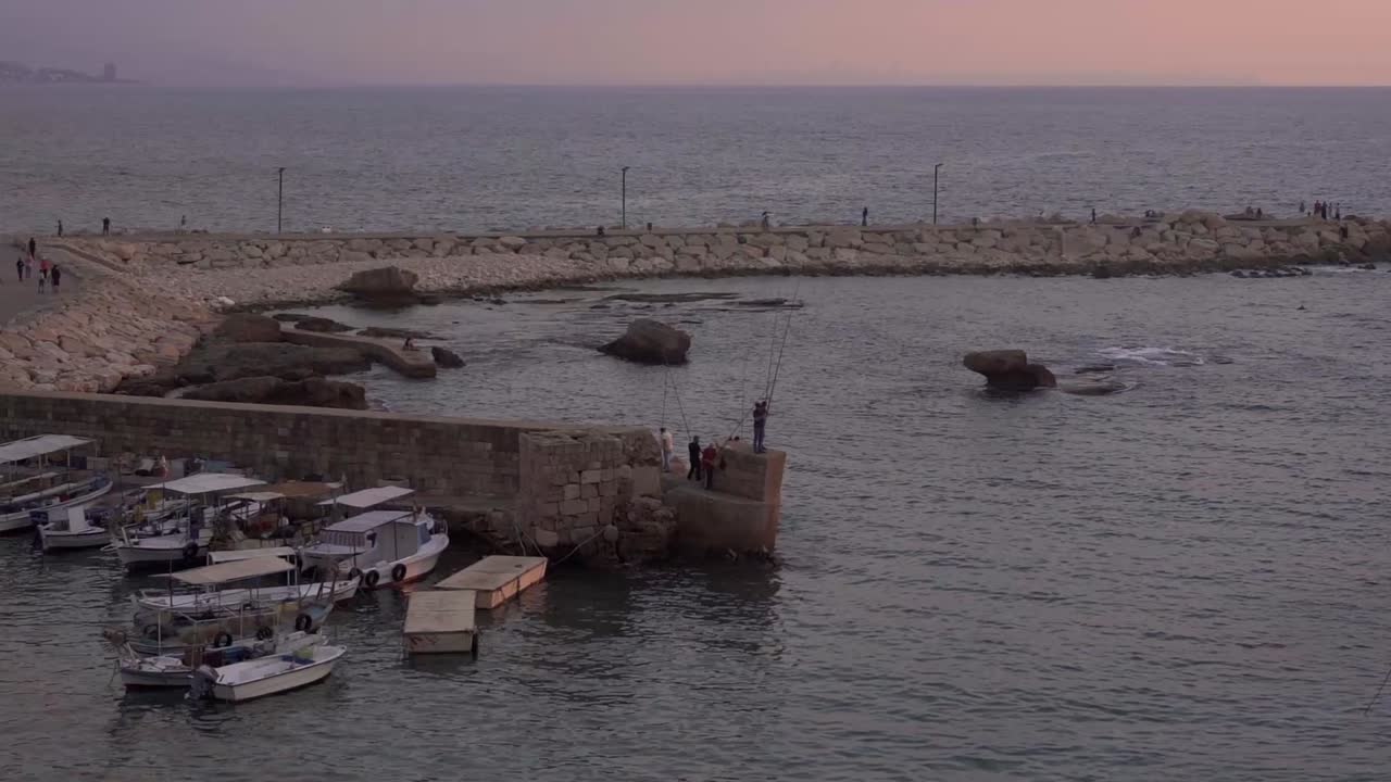 barcos amarrados cerca de la pared de piedra en el viejo puerto al atardecer