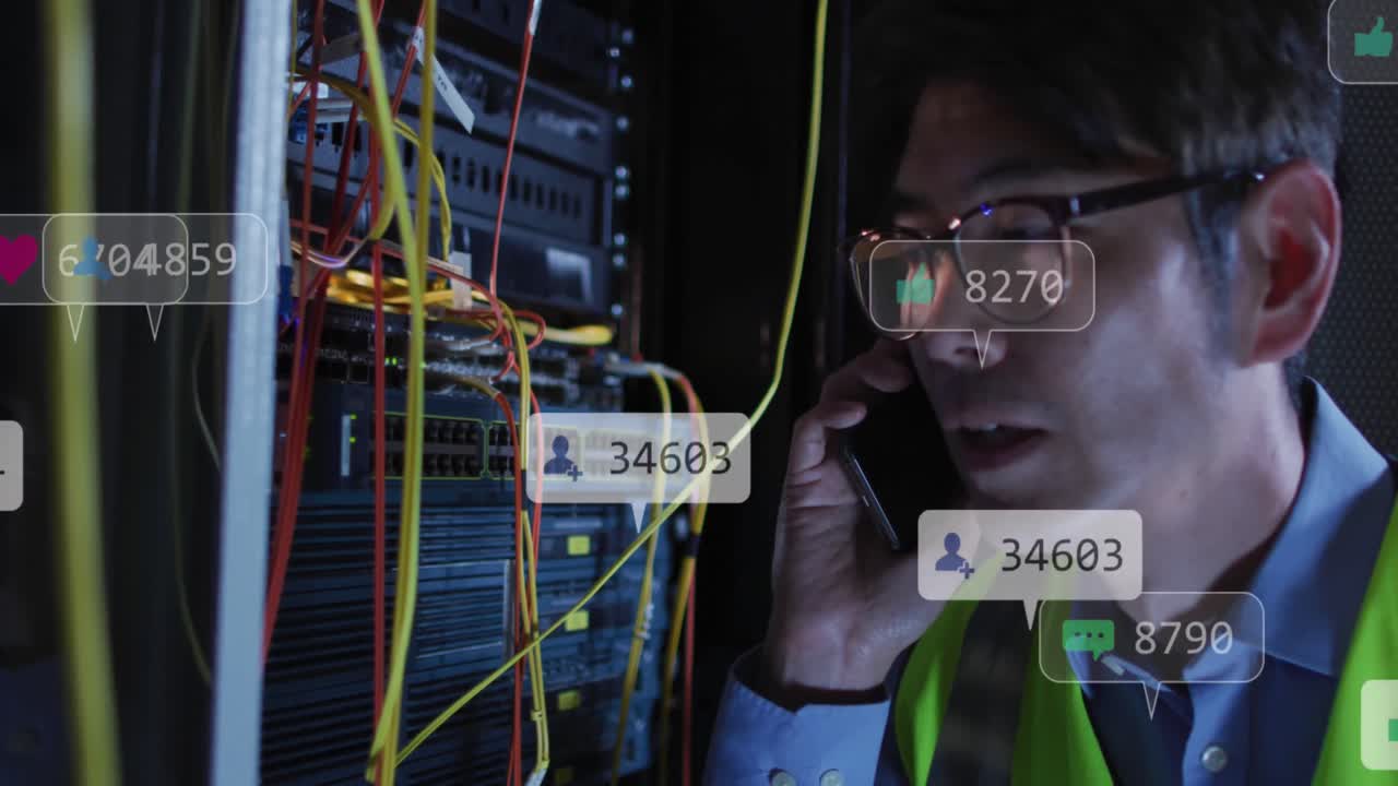 Animation of social media icons over asian male engineer talking on smartphone at server room