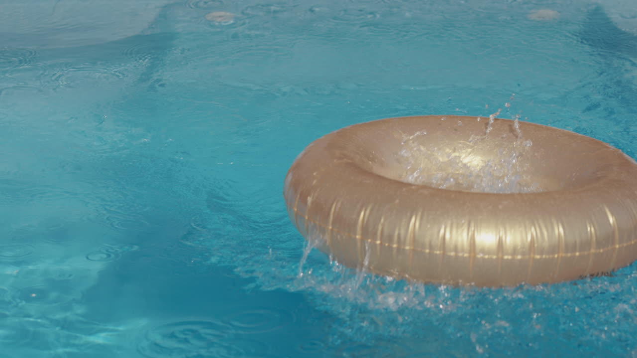 un niño hábil salta al medio de un círculo inflable que nada en la piscina