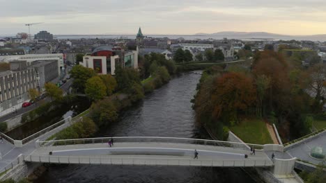 Gente-Cruzando-Un-Puente-Peatonal-En-La-Ciudad-De-Galway.