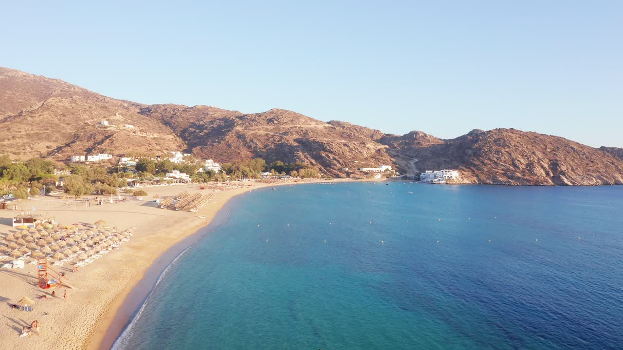 Aerial bird's eye view video taken by drone of beautiful Milopotas beach at sunset, Cyclades, Greece