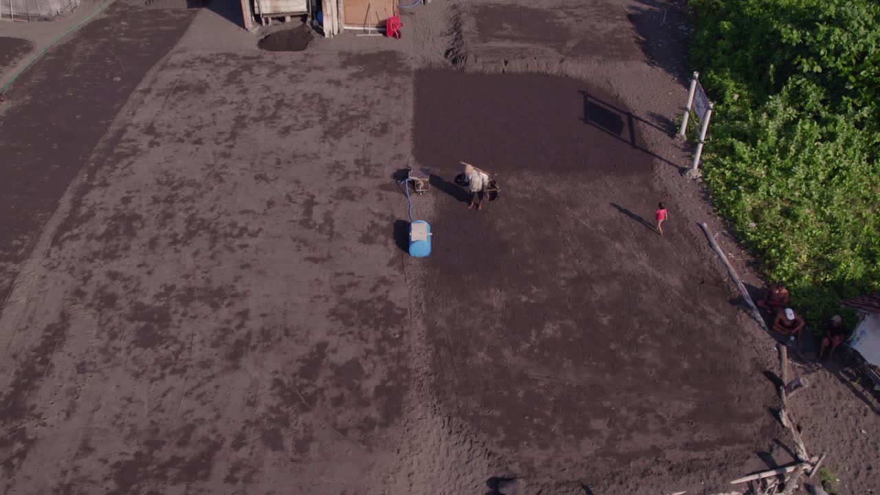 Salinai locali su spiaggia di sabbia nera a Klungkung, Bali