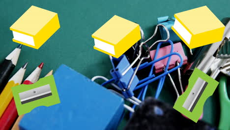 animation of green pencil sharpeners and yellow books moving over assorted school stationery