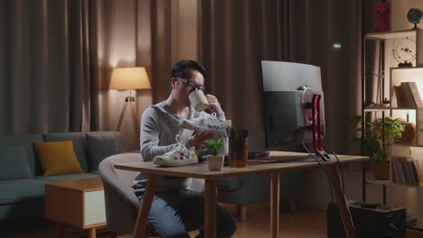 man working at home on a computer and drinking coffee, examining art design shoes