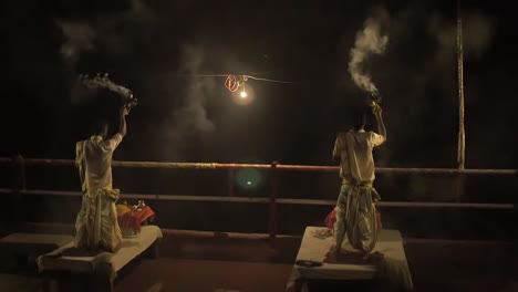 two men performing the ganga aarti ceremony