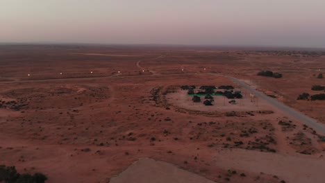 aerial shot in the morning of army tents in the middle of the big desert at a training camp