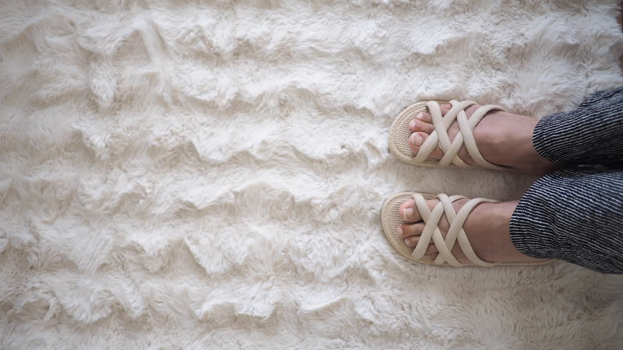 Feet on a fluffy rug with sandals