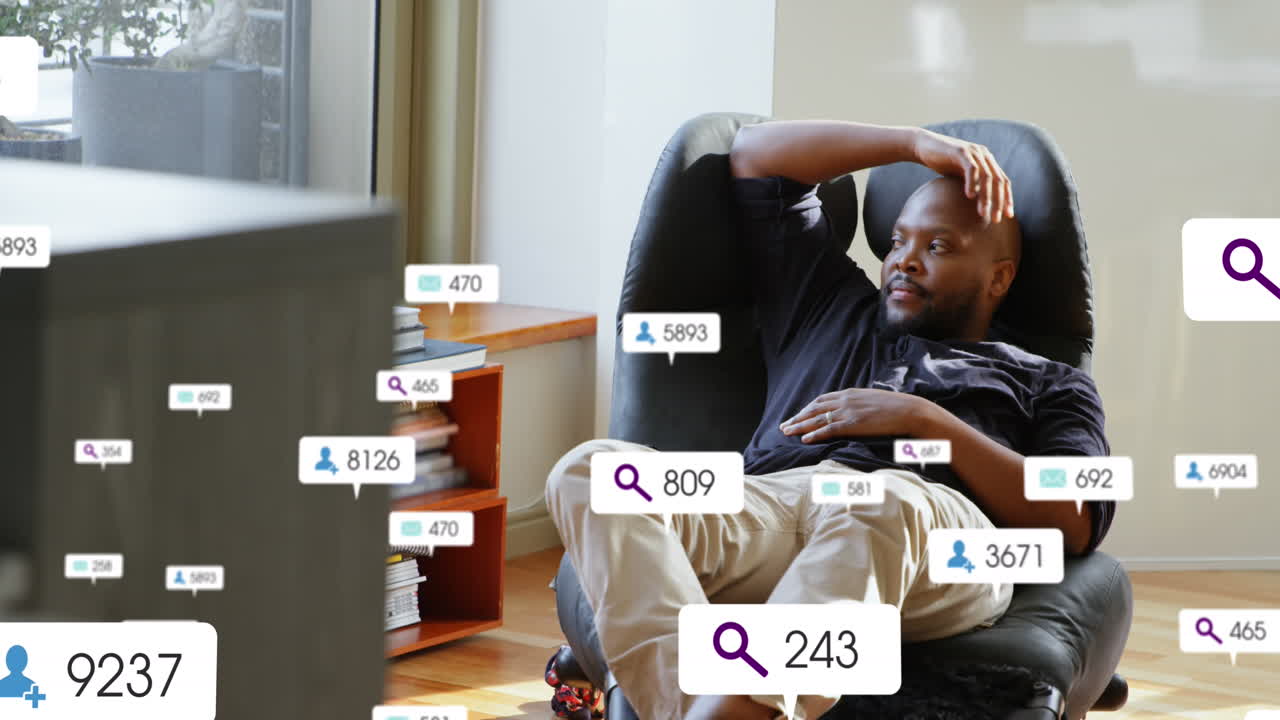 animación de iconos de las redes sociales sobre un hombre afroamericano mirando por la ventana de su casa.