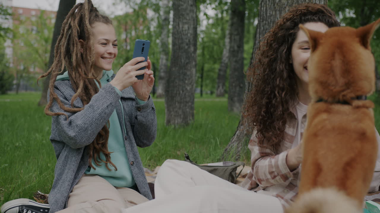Friends enjoying a picnic in the park with a dog