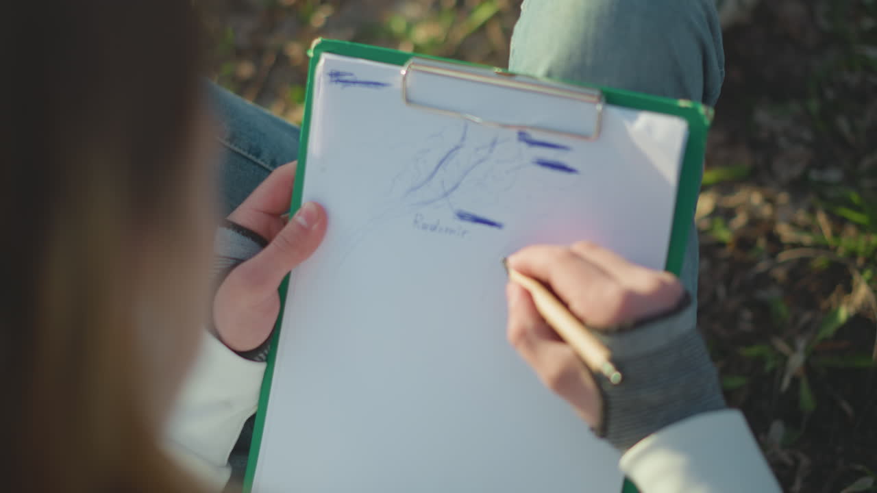 creative lady sketching natural patterns, outdoor art session with woman exploring shapes and textures, an outdoor setting where woman creates abstract lines and patterns on her clipboard