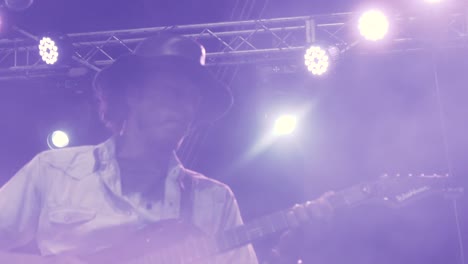 close up in slow motion of a guitarist performing a song in a night outdoor concert