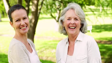 Mother-and-adult-daughter-laughing-and-chatting-in-the-park