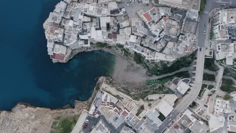 Top-down-aerial-footage-of-the-town-of-Polignano-a-Mare-in-the-morning-with-a-calm-sea-and-some-traffic