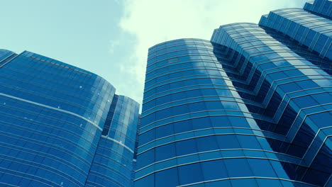 Modern-business-architecture-with-glass-and-steel-walls-reflecting-sky-clouds