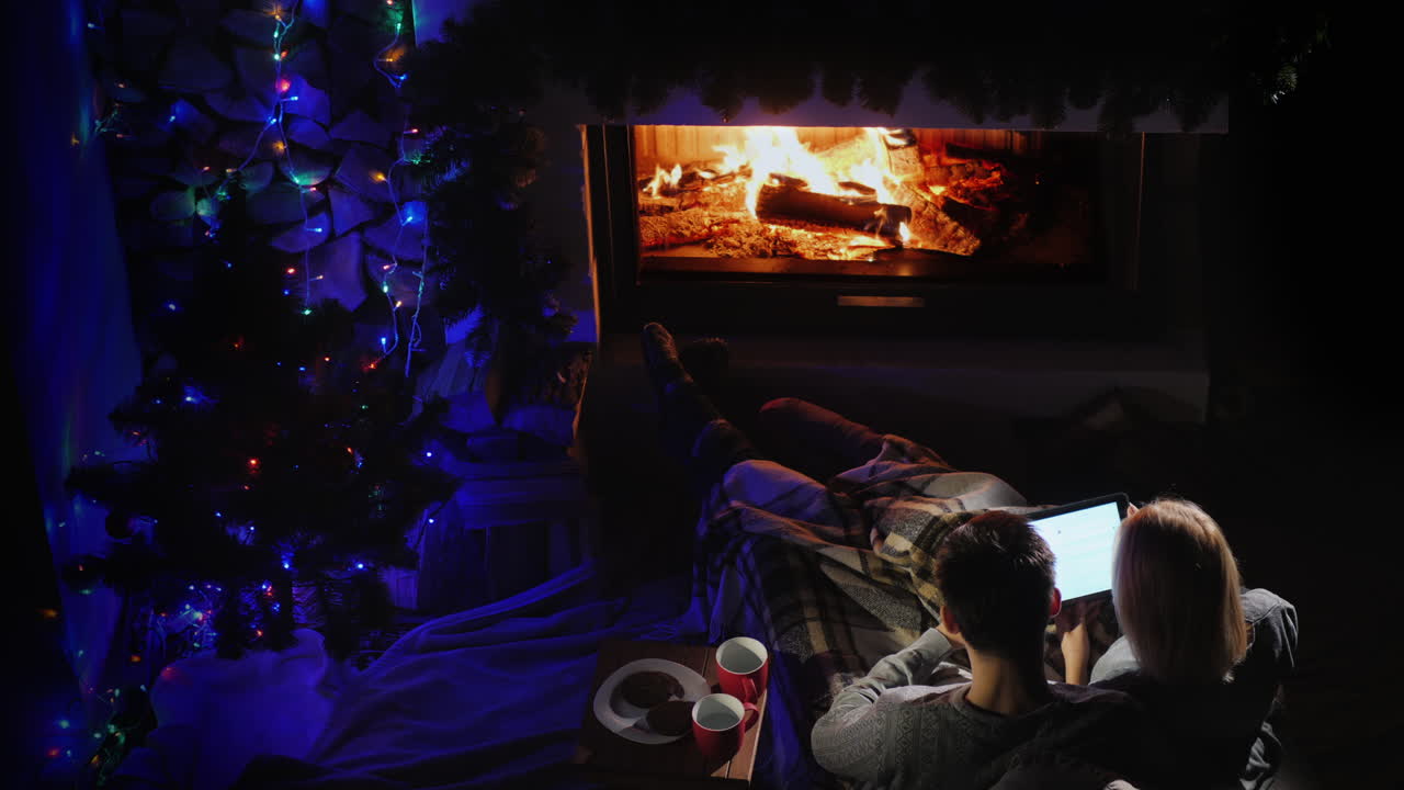 pareja joven admira el fuego en la vista superior de la chimenea