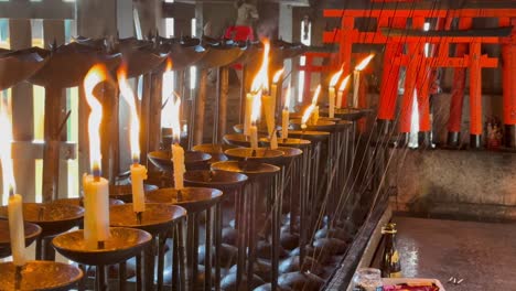 lit candles and flames in fushimi inari taisha in japan