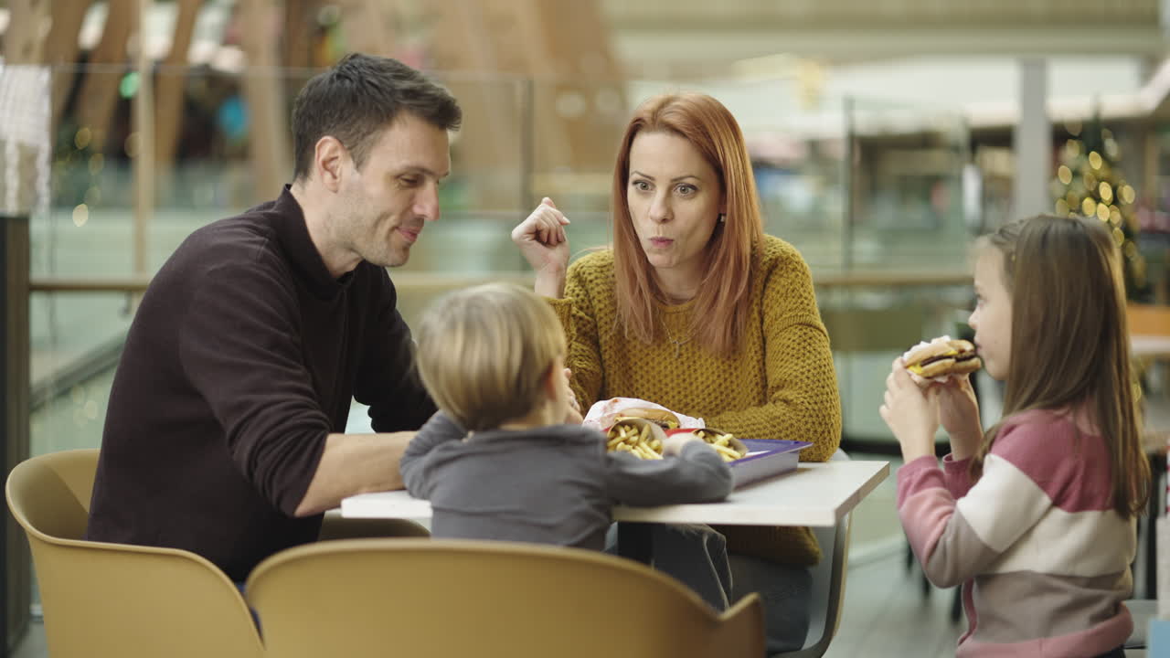 Family Enjoying Fast Food at a Mall Food Court
