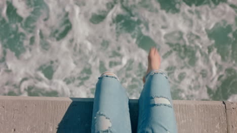 Frauenbeine-Baumeln-Barfuß-über-Dem-Wasser.-Mädchen-Genießt-Den-Sommerurlaub,-Sitzt-Am-Pier-Am-Meer-Und-Beobachtet-Wellen.-Freiheitskonzept