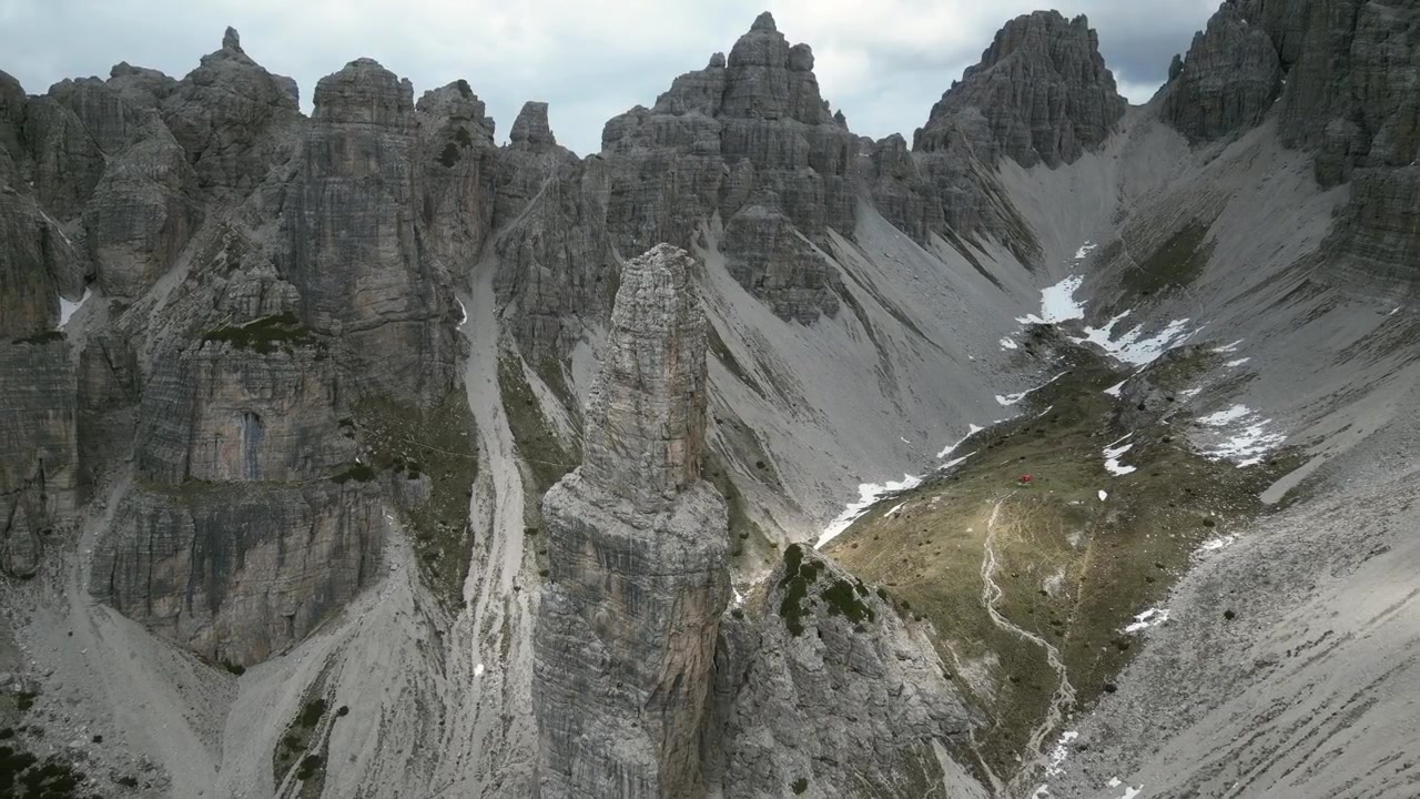 Riprese aeree con drone del Campanile di Val Montanaia, Italia: una spettacolare guglia di roccia verticale che si erge sopra una valle alpina e un aspro paesaggio dolomitico. Ideale per progetti sulla natura e l'avventura