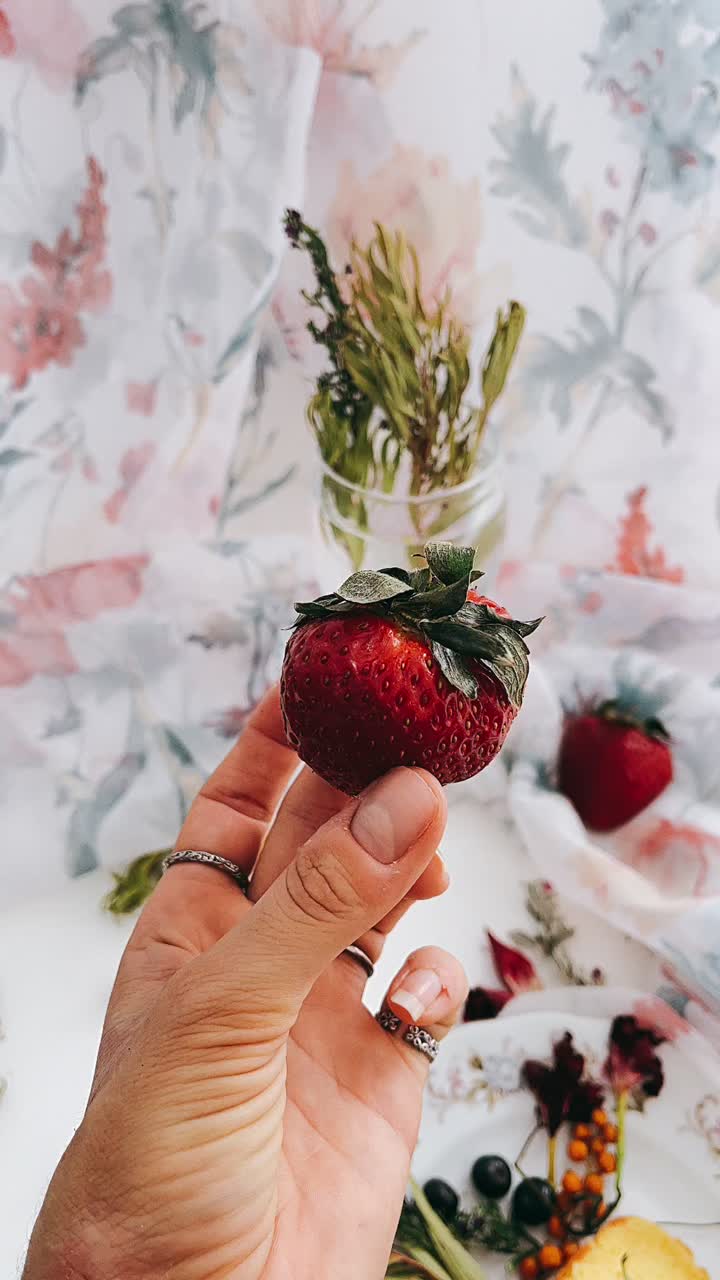Strawberry in Hand with Floral Decor