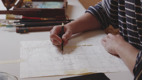 drawing an illustration of female figure on squared paper with pencil