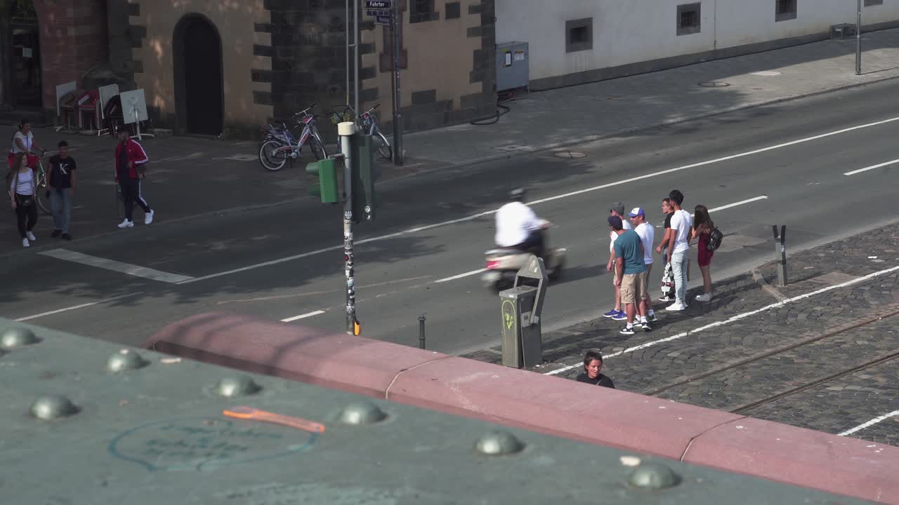 View from top of bridge of people waiting on a stop light on the streets of Frankfrut in the Summer