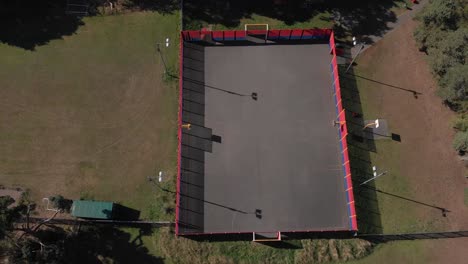 Cancha-Deportiva-Para-Deportes-Con-Pelota,-Juegos-Infantiles-Al-Aire-Libre-Desde-Una-Perspectiva-Aérea,-Pista-Rodeada-De-árboles-Verdes-Y-Naturaleza