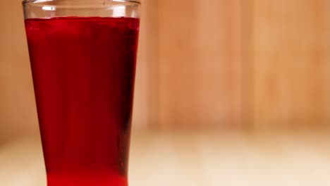 a glass filled with red soft drink