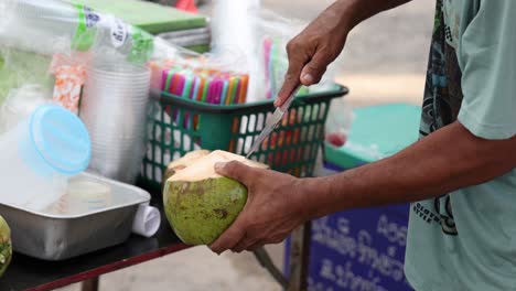 street vendor skillfully opening and serving coconut.