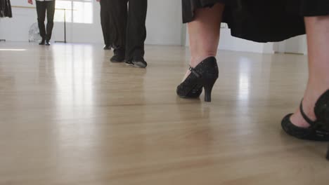 mixed race male dance teacher taking a ballroom dancing class at a dance studio