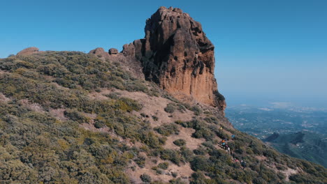 toma aerea en orbita sobre el famoso roque saucillo y donde se pueden ver turistas bajando la montaña