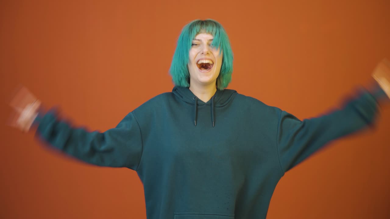 Young woman doing rocker sign and dancing.