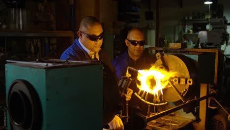dos trabajadores masculinos que crean vidrio en una fábrica de vidrio 4k