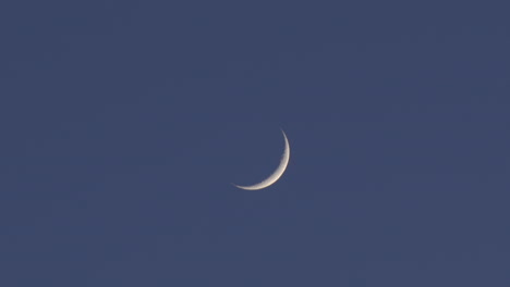 beautiful waxing crescent moon glowing in dark blue sky at twilight