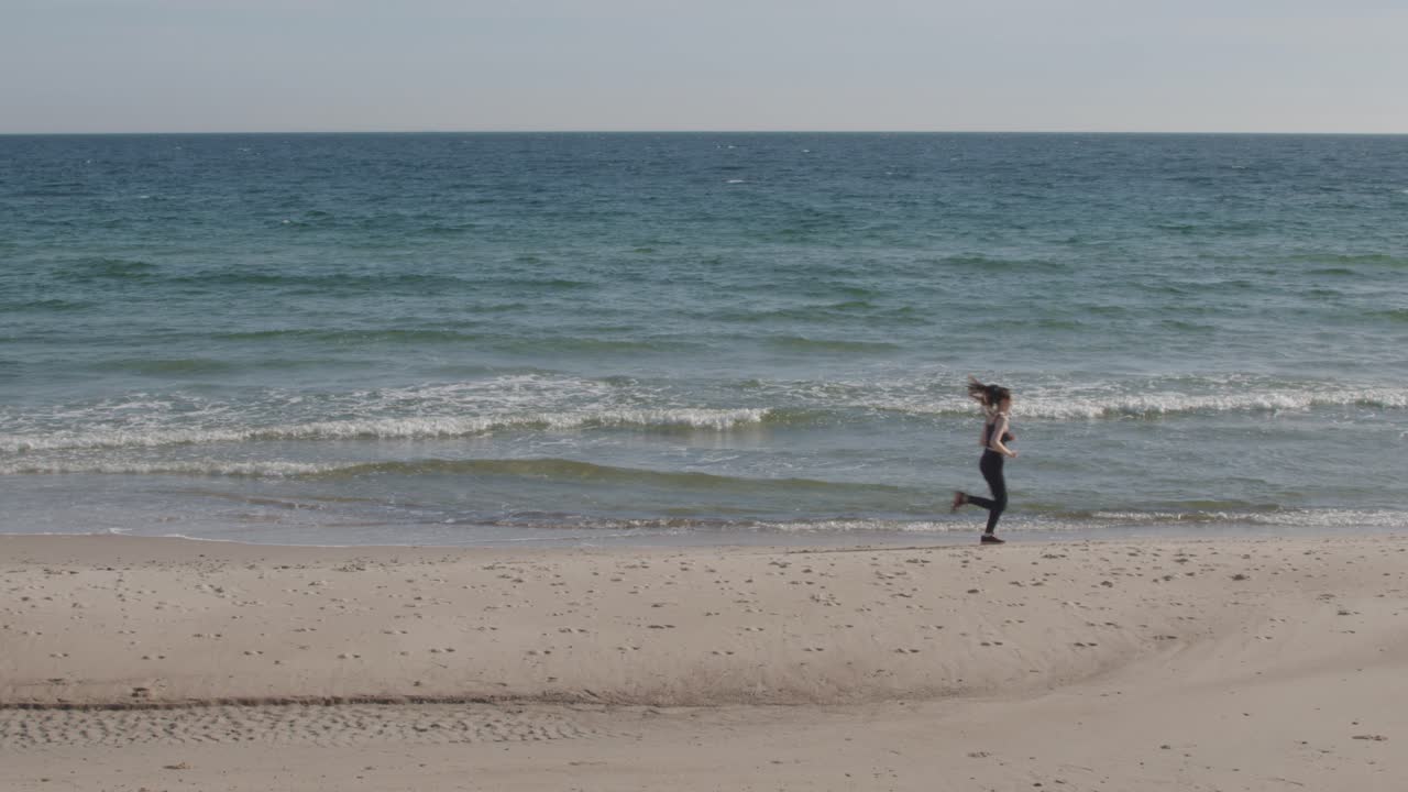 녹색 바다 푸른 하늘 수평선 밝은 모래 해변에서 조깅하는 젊은 피트니스 여성