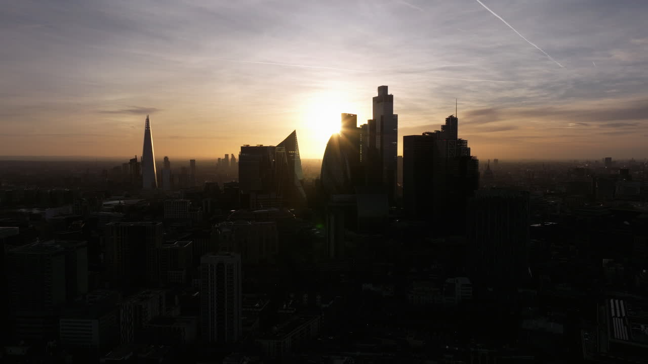 Toma aérea lenta y amplia con retroceso de dolly de la silueta de los rascacielos de la ciudad de Londres