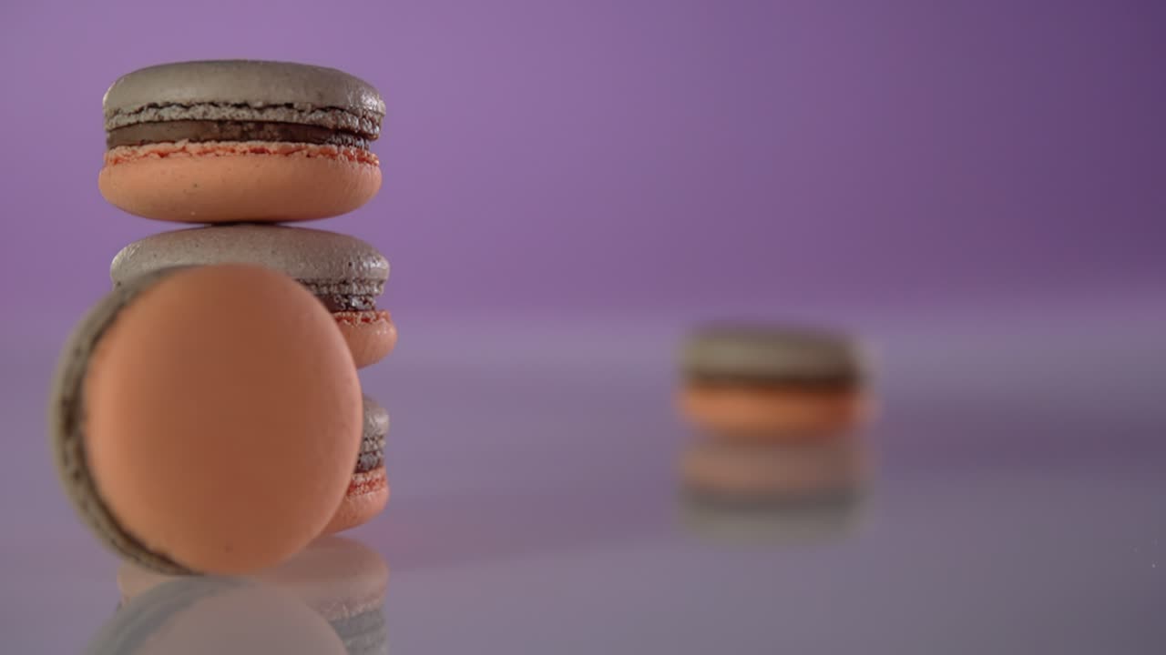 un macarrón rueda sobre una mesa y golpea una pila de tres macarrones