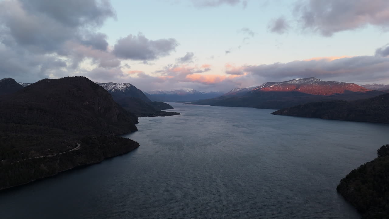 Stunning aerial view of Lake Lácar surrounded by the Andes mountain range at sunrise with dramatic sky. Argentina.