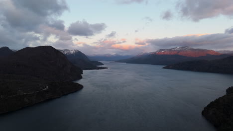 stunning aerial view of lake lácar surrounded by the andes mountain range at sunrise with dramatic sky. argentina.
