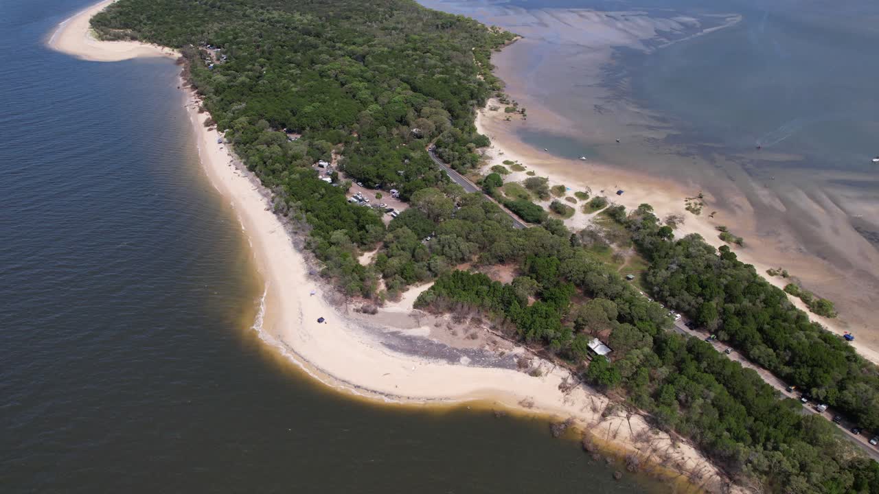 Campground At Inskip Point With Lush Vegetation In Rainbow Beach, Queensland, Australia. aerial pullback shot