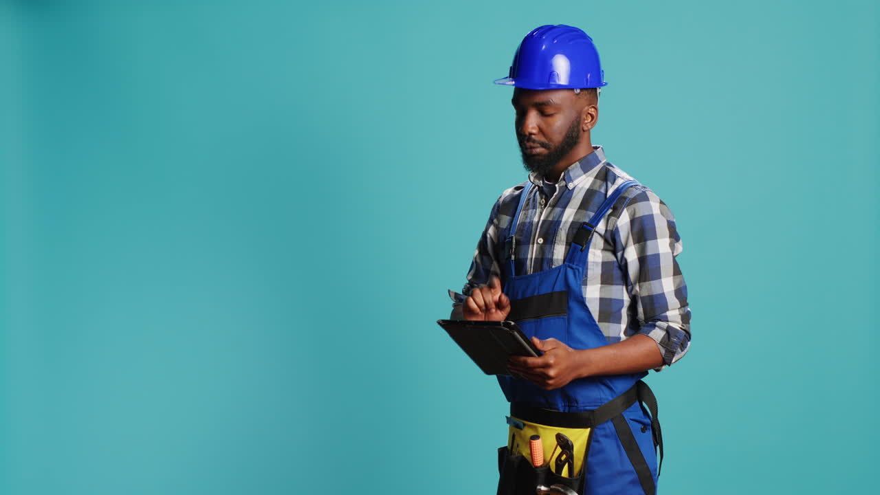 Confident mechanic using tablet for calculations