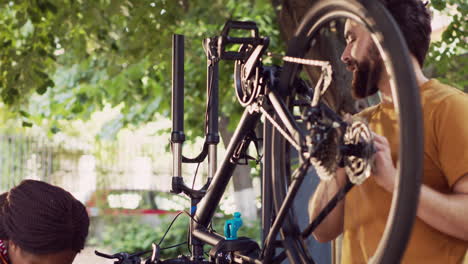 Pareja-Multirracial-Inspecciona-Bicicleta-Rota